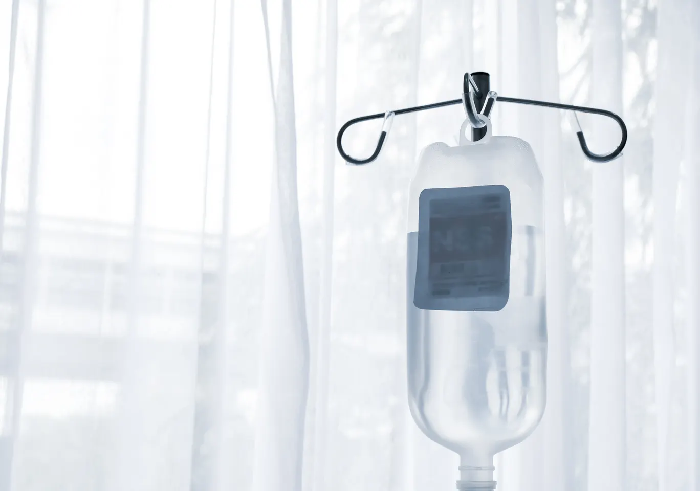 Kroplówki witaminowe Kozienice: butelka płynu infuzyjnego zawieszona przy oknie