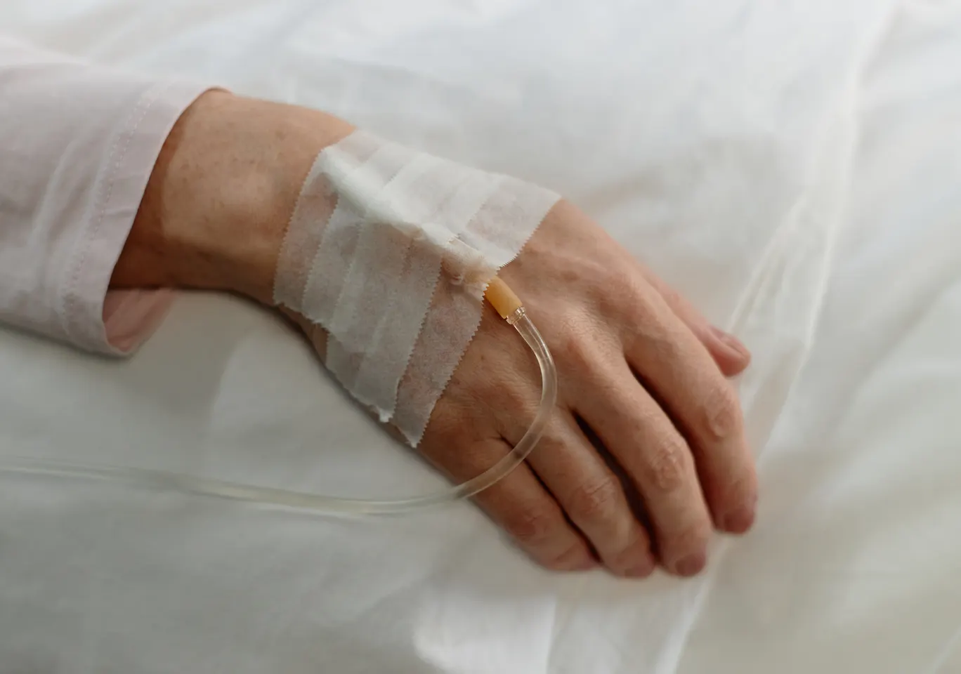 Kroplówki witaminowe Grójec: dłoń z podłączoną kroplówką w spokojnym kadrze