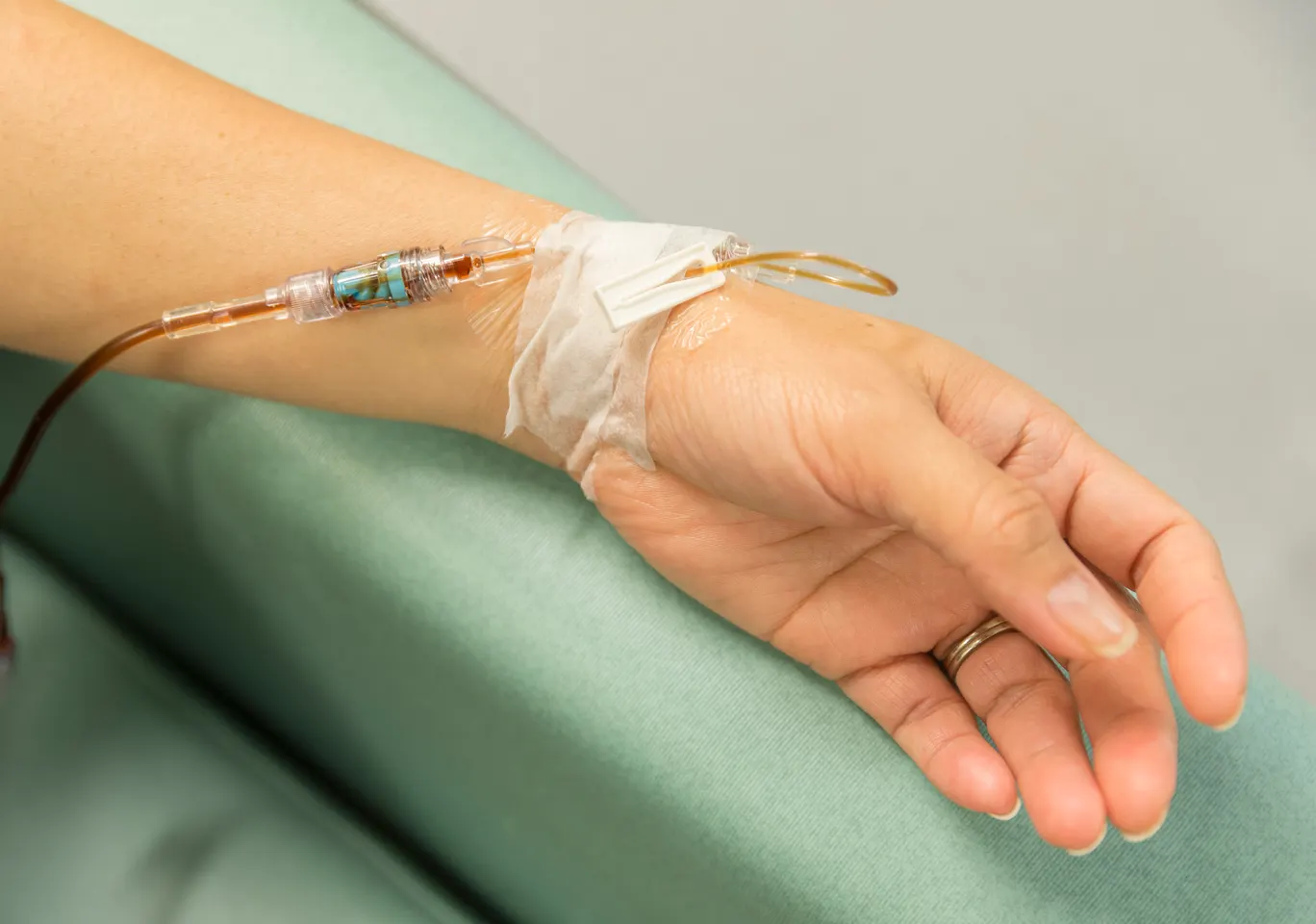 Kroplówki witaminowe Szydłowiec: dłoń z wenflonem i linią infuzyjną na podkładzie