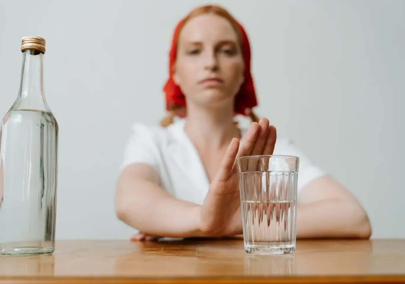 Leczenie alkoholizmu Radom: kobieta odsuwa butelkę i sięga po wodę