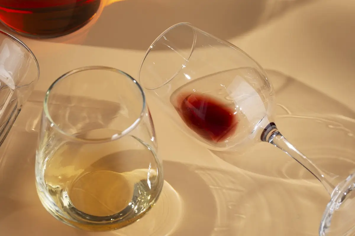 Pusta szklanka po drinku i przewrócony kieliszek jako symbol uzależnienia